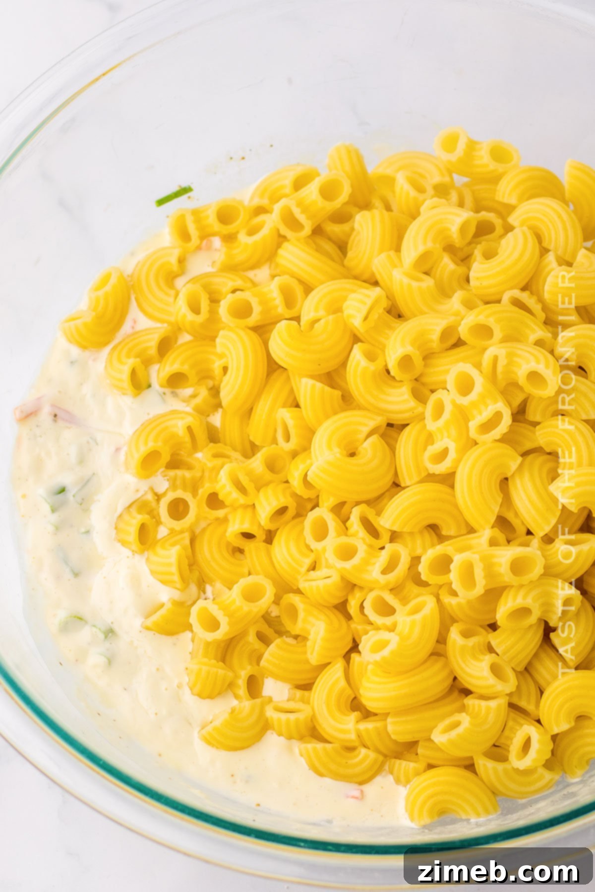 Creamy Hawaiian Macaroni Salad 5 Mixing the noodles with the sauce for Hawaiian Macaroni Salad
