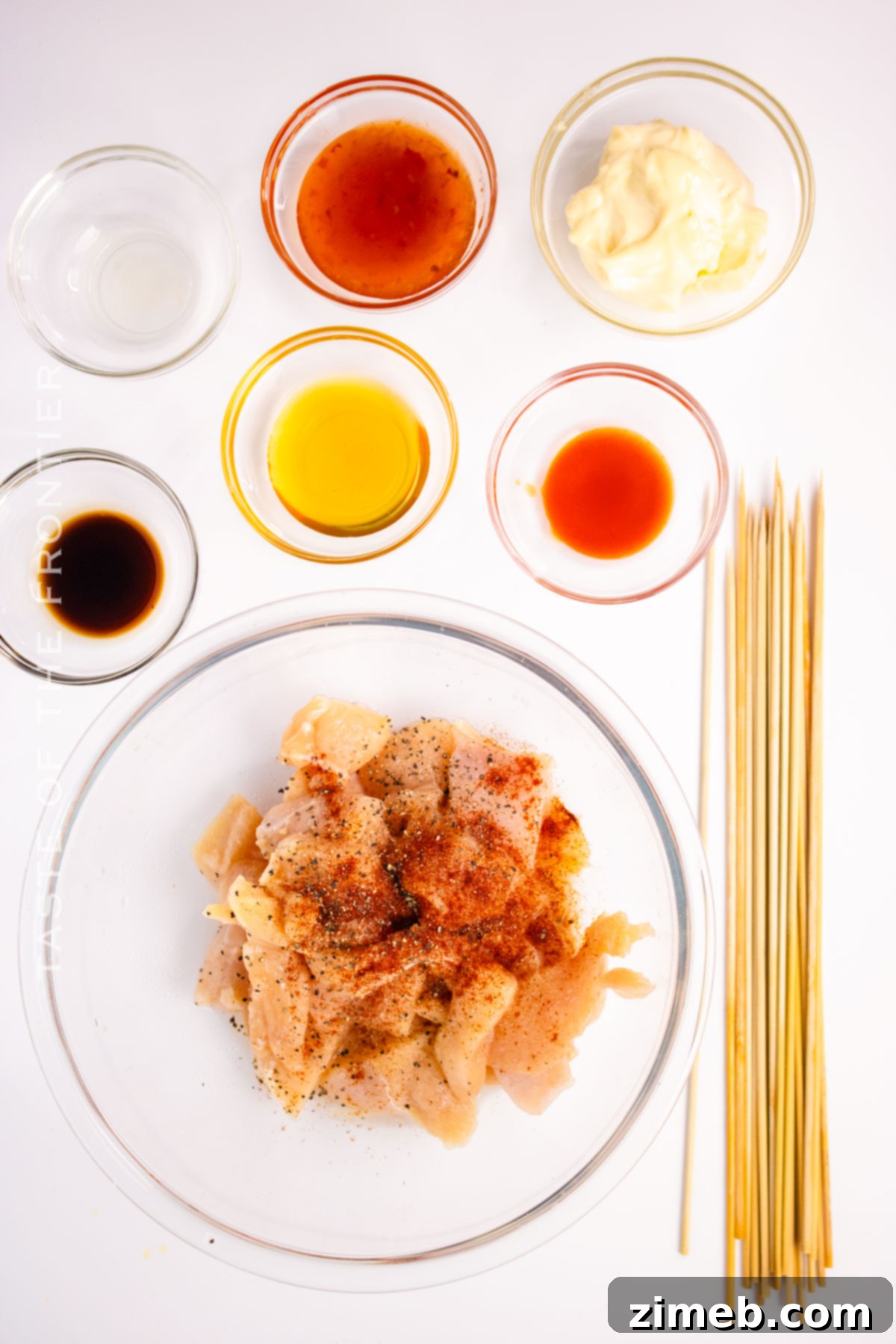 Chicken Skewers with Bang Bang Sauce 4 Ingredients laid out for Bang Bang Chicken Skewers, including cubed chicken pieces, mayonnaise, sweet chili sauce, honey, rice vinegar, hot sauce, and sesame oil.