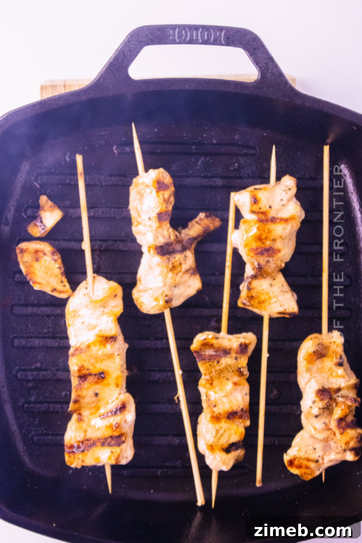 Chicken Skewers with Bang Bang Sauce 6 Assembling chicken skewers, showing seasoned chicken pieces being threaded onto wooden skewers.