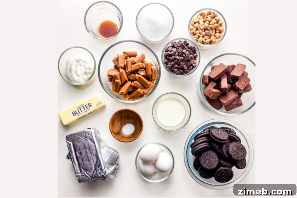 Essential ingredients for a homemade Snickers Cheesecake, including Oreos, cream cheese, Snickers bars, and caramel.
