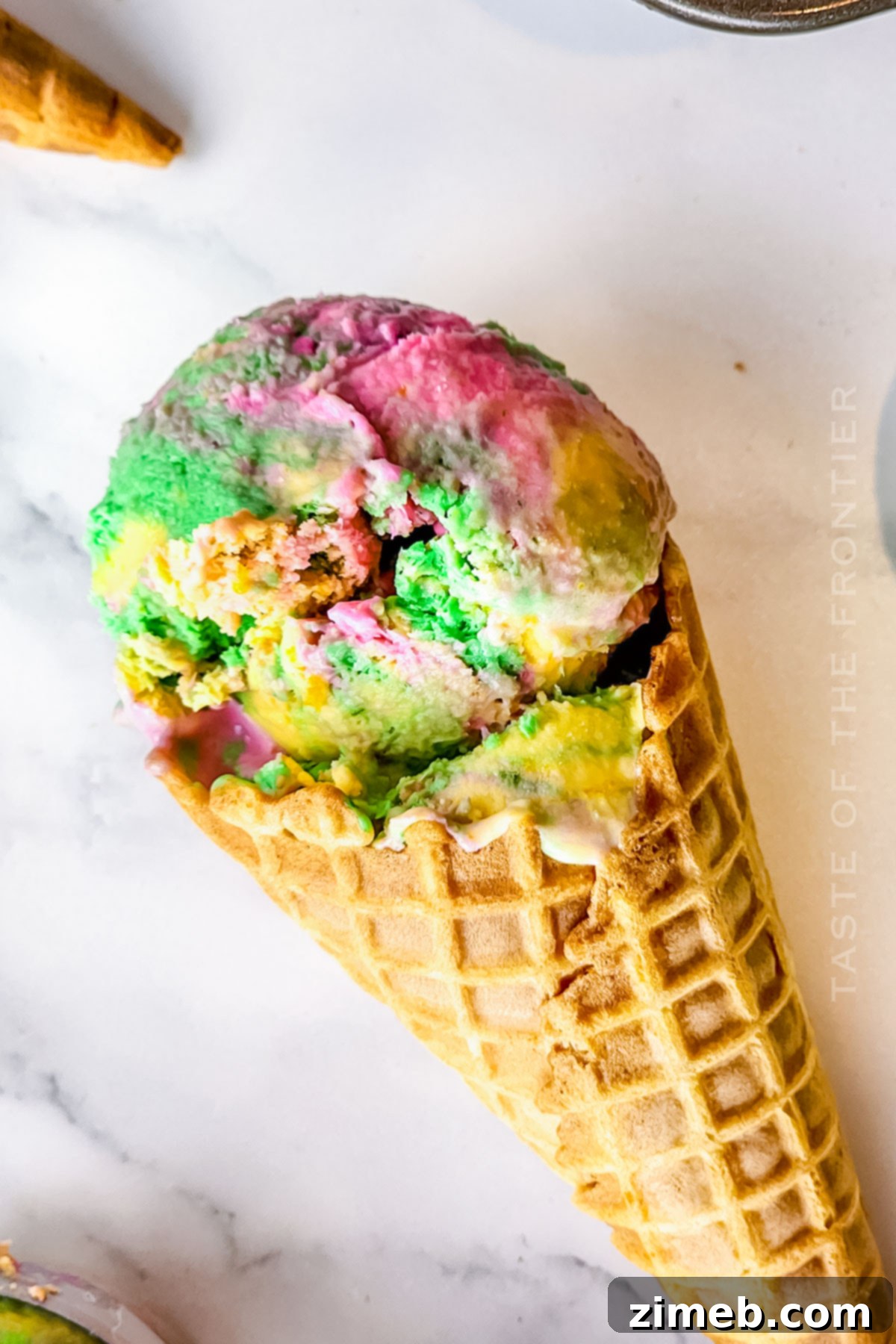 Refreshing frozen treat in a cone, showcasing the colorful layers of Rainbow Sherbet