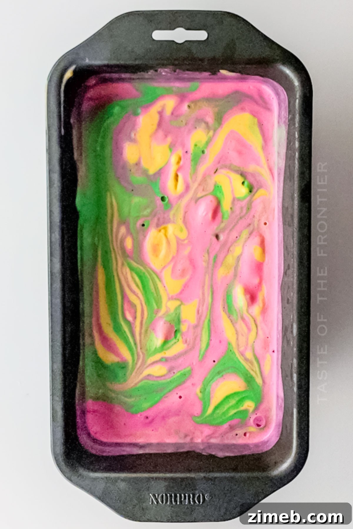 Close-up of swirled rainbow sherbet in a loaf pan before final freezing
