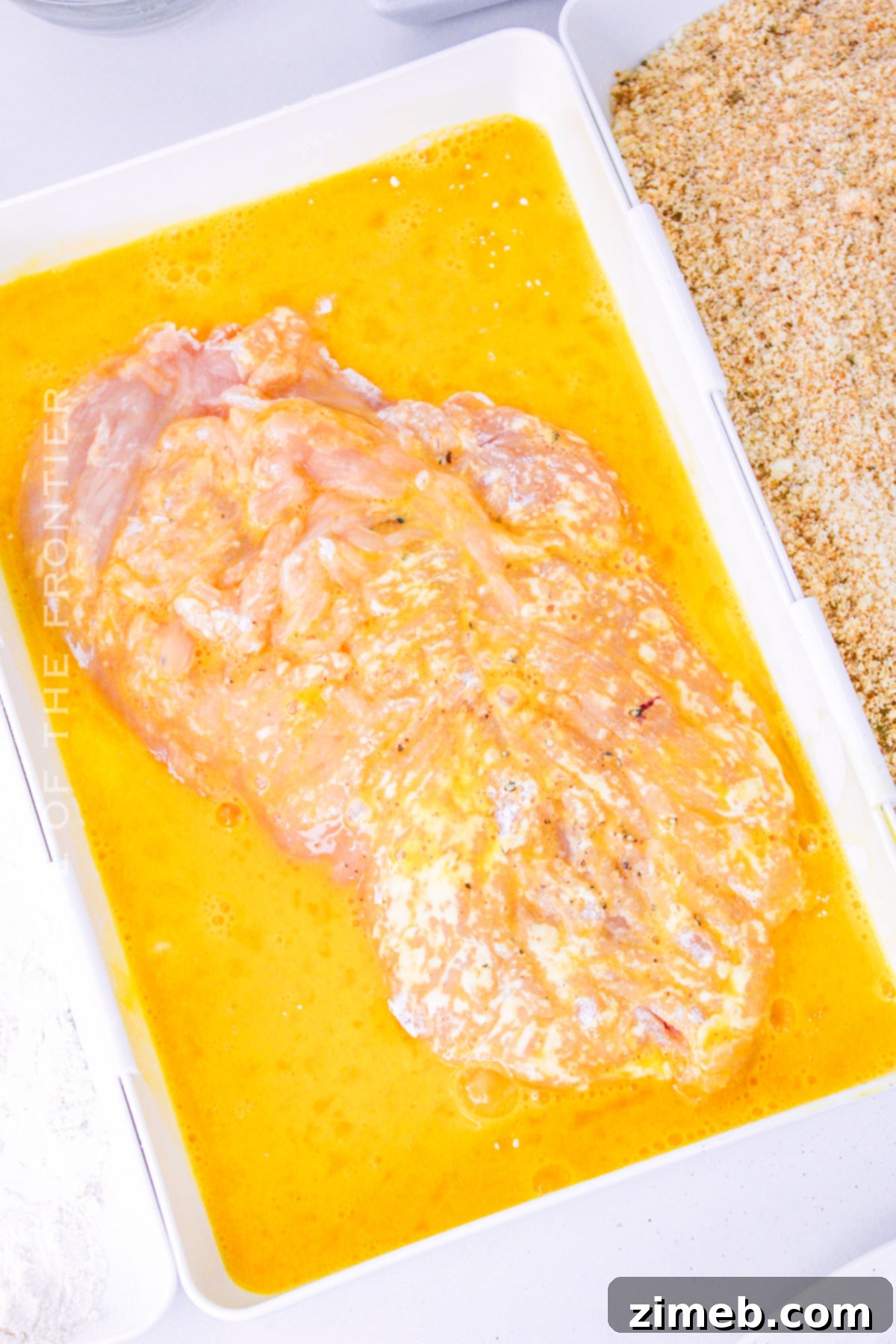 Coating chicken in egg wash as part of breading process