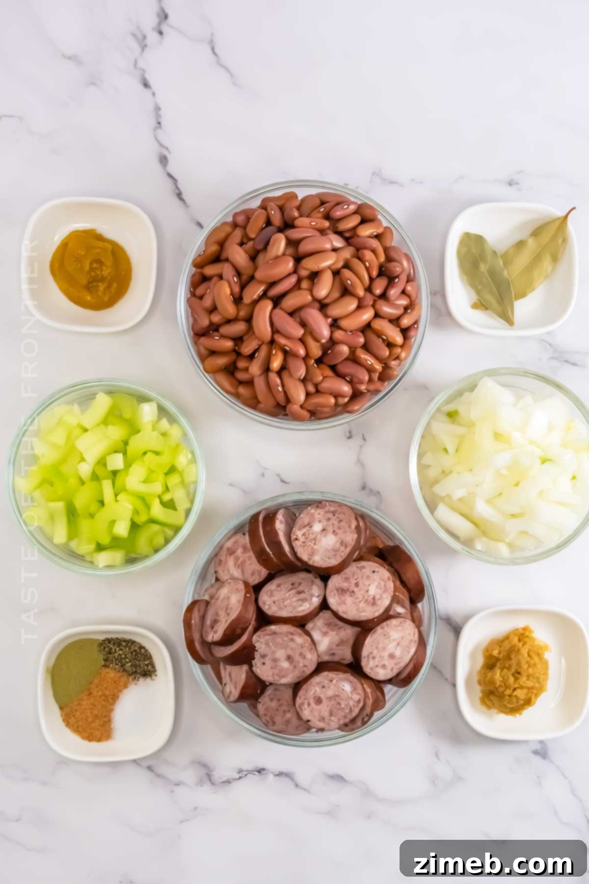 All the fresh ingredients laid out for Crockpot Red Beans & Rice, including dry red beans, sliced Andouille sausage, diced celery, onion, and garlic.