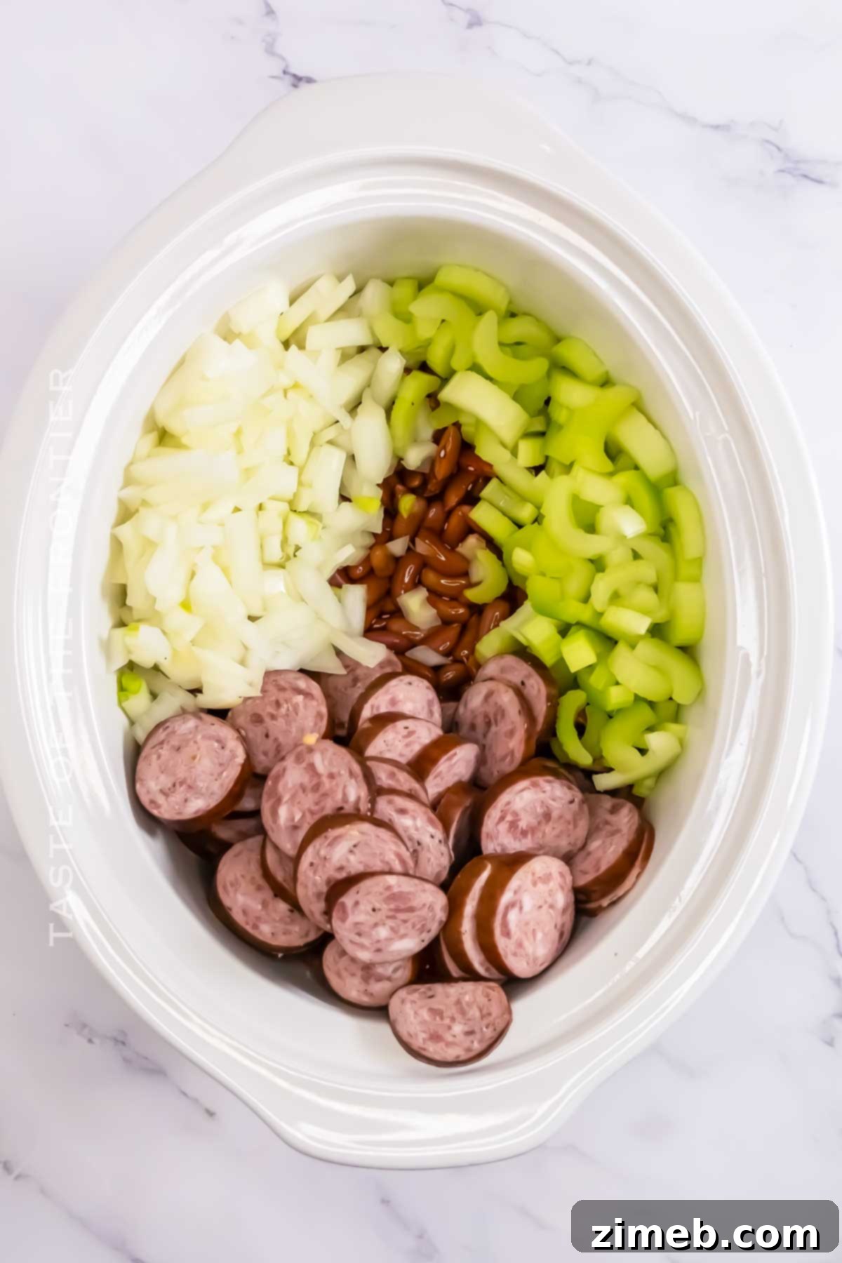 Close-up of slow cooker Red Beans & Rice bubbling gently, showcasing the creamy beans and sausage pieces.