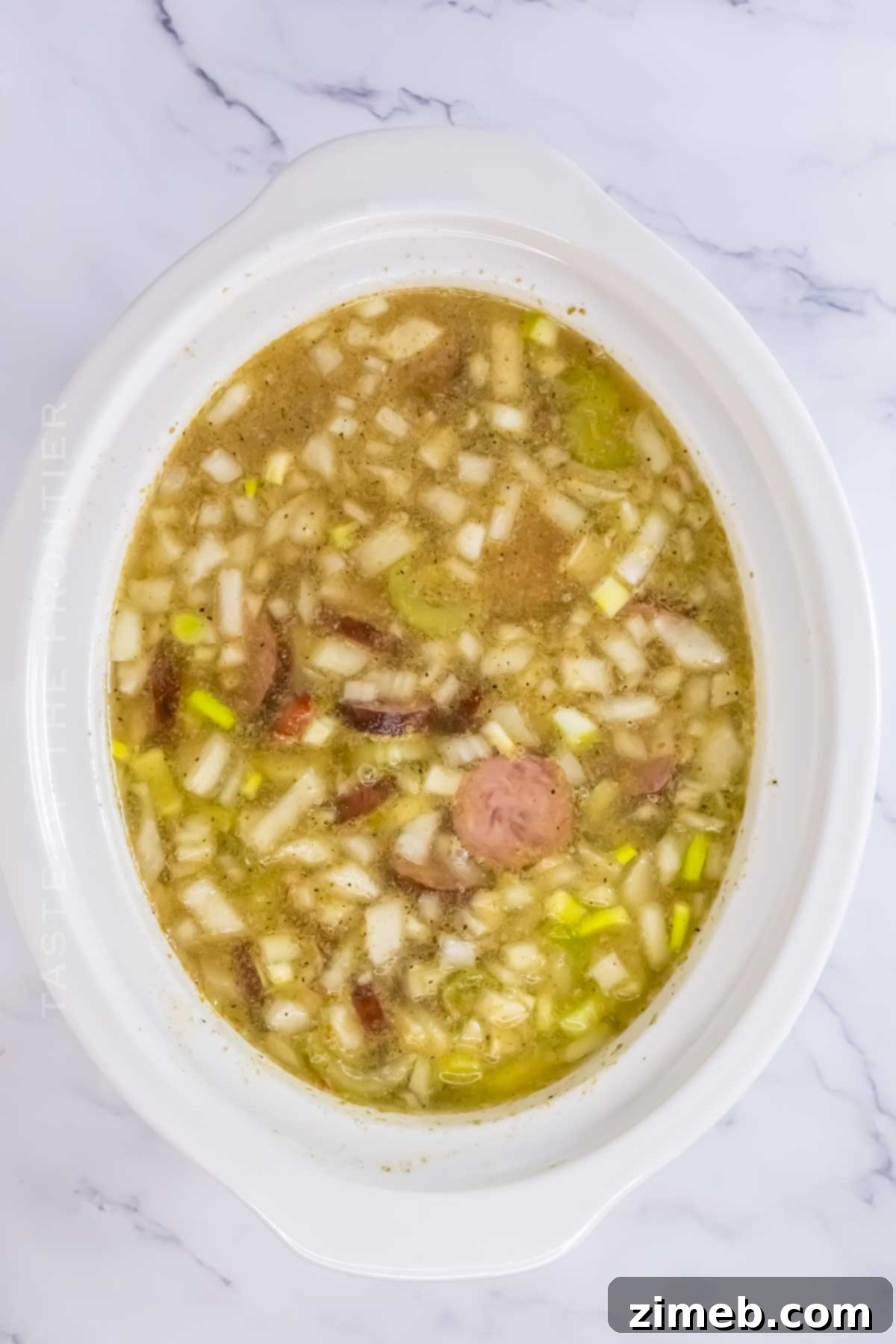 A slow cooker filled with Crockpot Red Beans & Rice, cooking slowly to perfection.