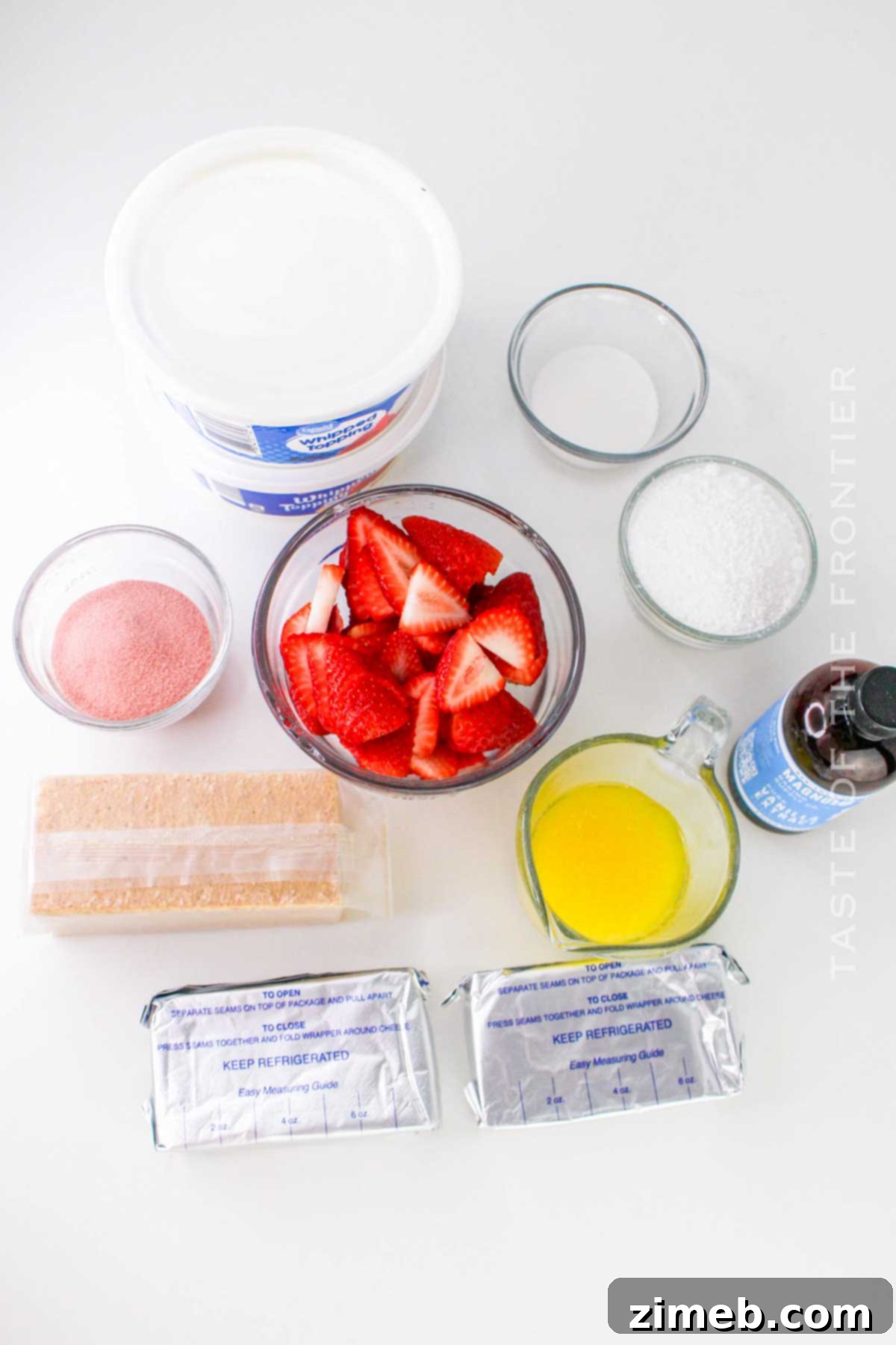Crimson Indulgence 4 Ingredients laid out for Strawberry Delight: graham cracker crumbs, strawberries, cream cheese, vanilla, sugar, and gelatin mix.