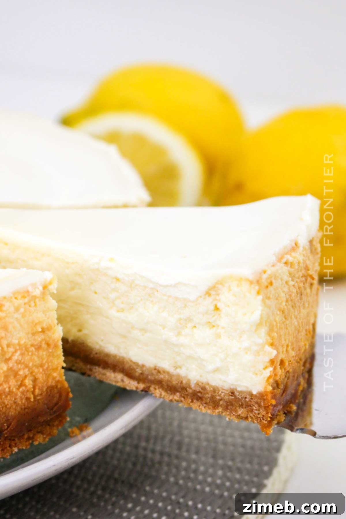 Lemon Cheesecake with a smooth sour cream layer and lemon garnish.