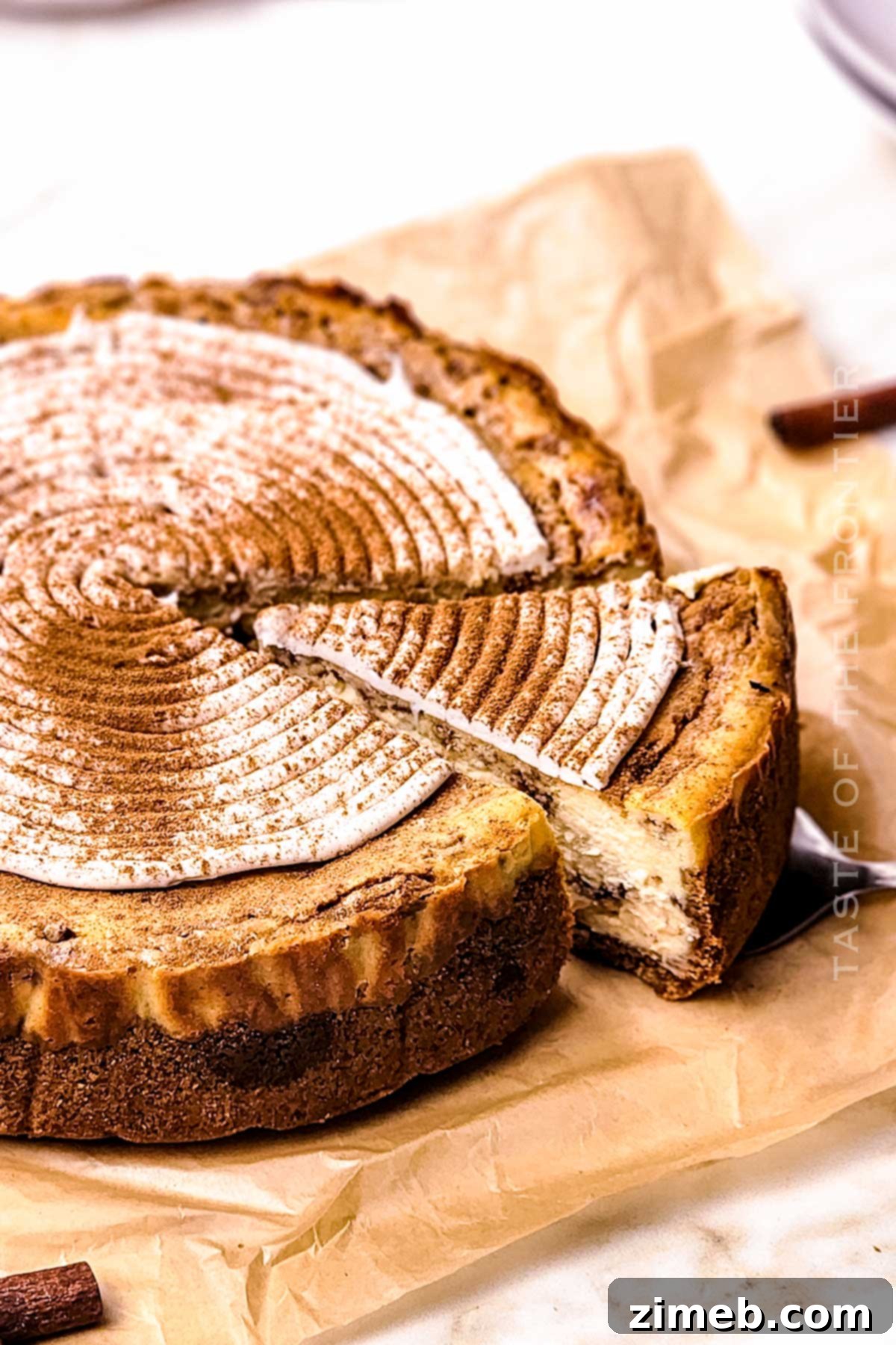 Serving a slice of homemade Cinnamon Roll Cheesecake