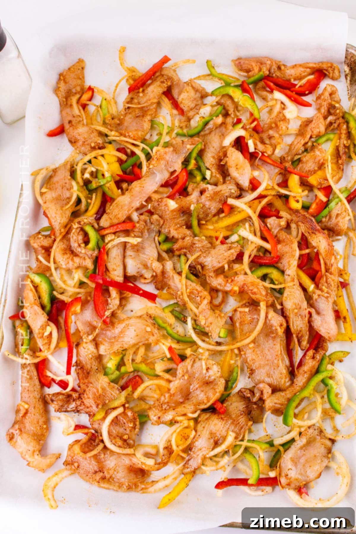 Sizzling Chicken Fajita Wraps 6 Baking chicken and vegetables on a sheet pan for fajitas.