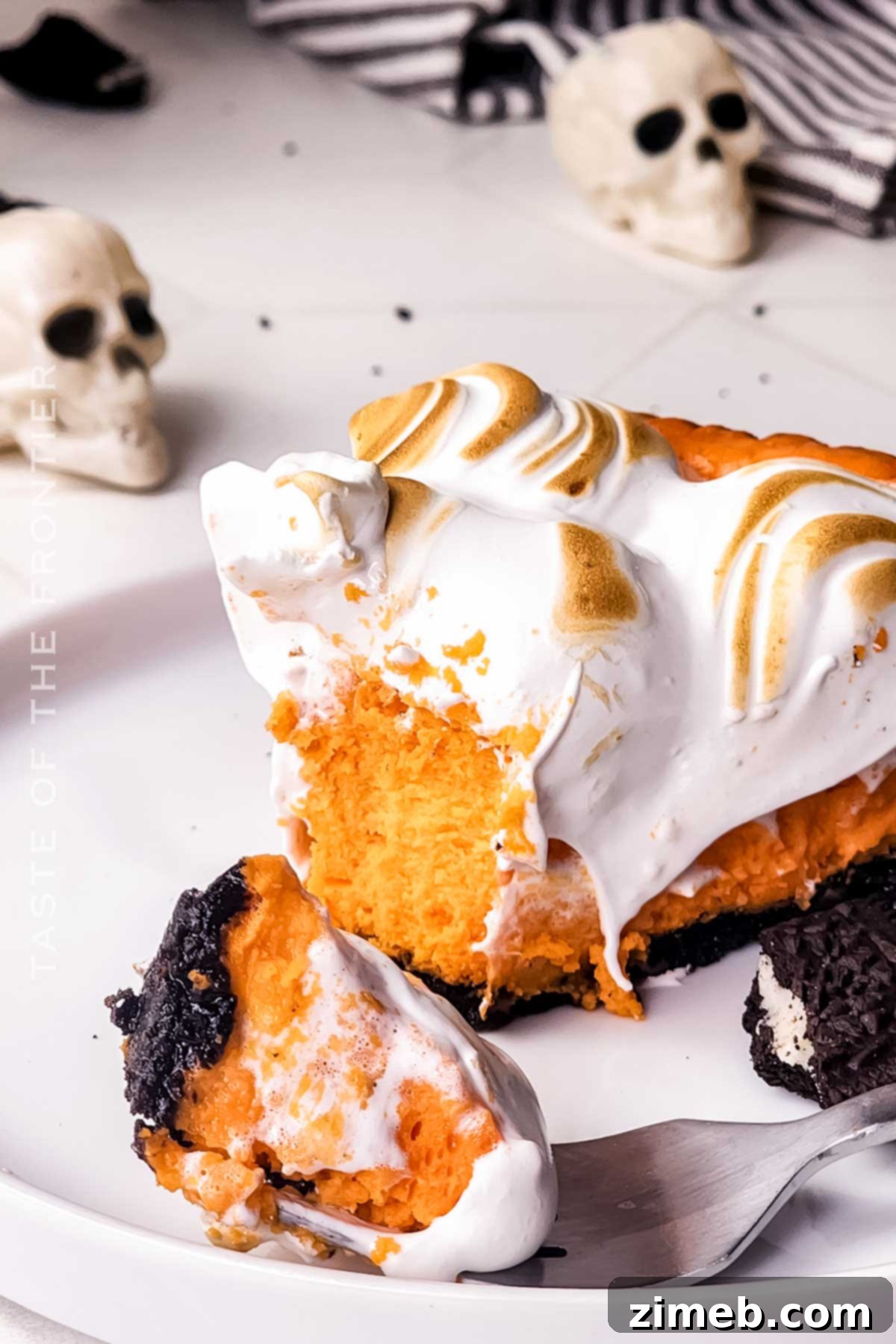 Spooktacular Cheesecake 17 A delicious slice of orange cheesecake for Halloween, showing the creamy texture and Oreo crust.