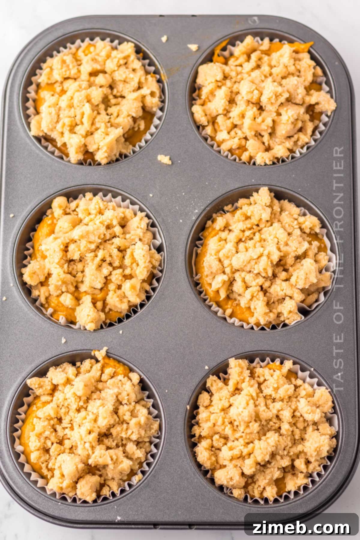 Costco's Irresistible Pumpkin Muffins 6 Muffin batter in a jumbo muffin tin, topped with streusel, ready to bake.