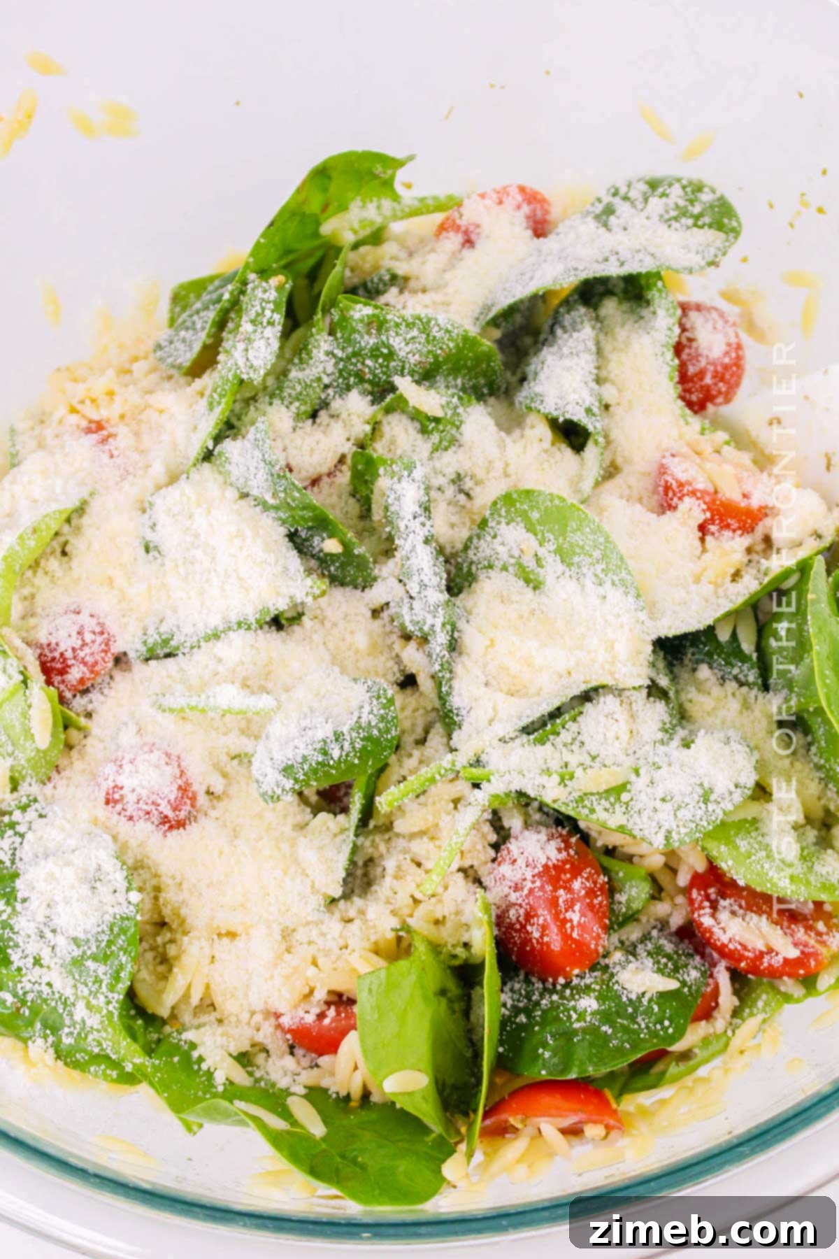 Vibrant Pesto Orzo Medley 7 Mixing Pesto Orzo Salad with grated Parmesan cheese