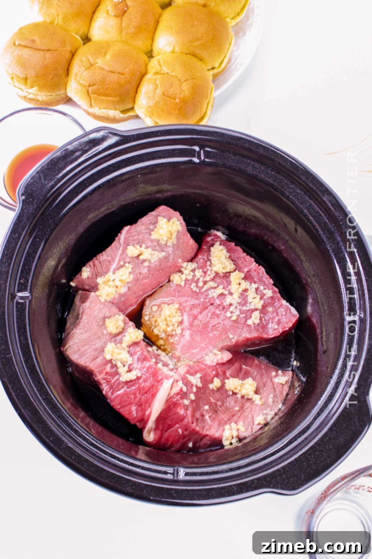 Slow cooker beef being shredded with forks