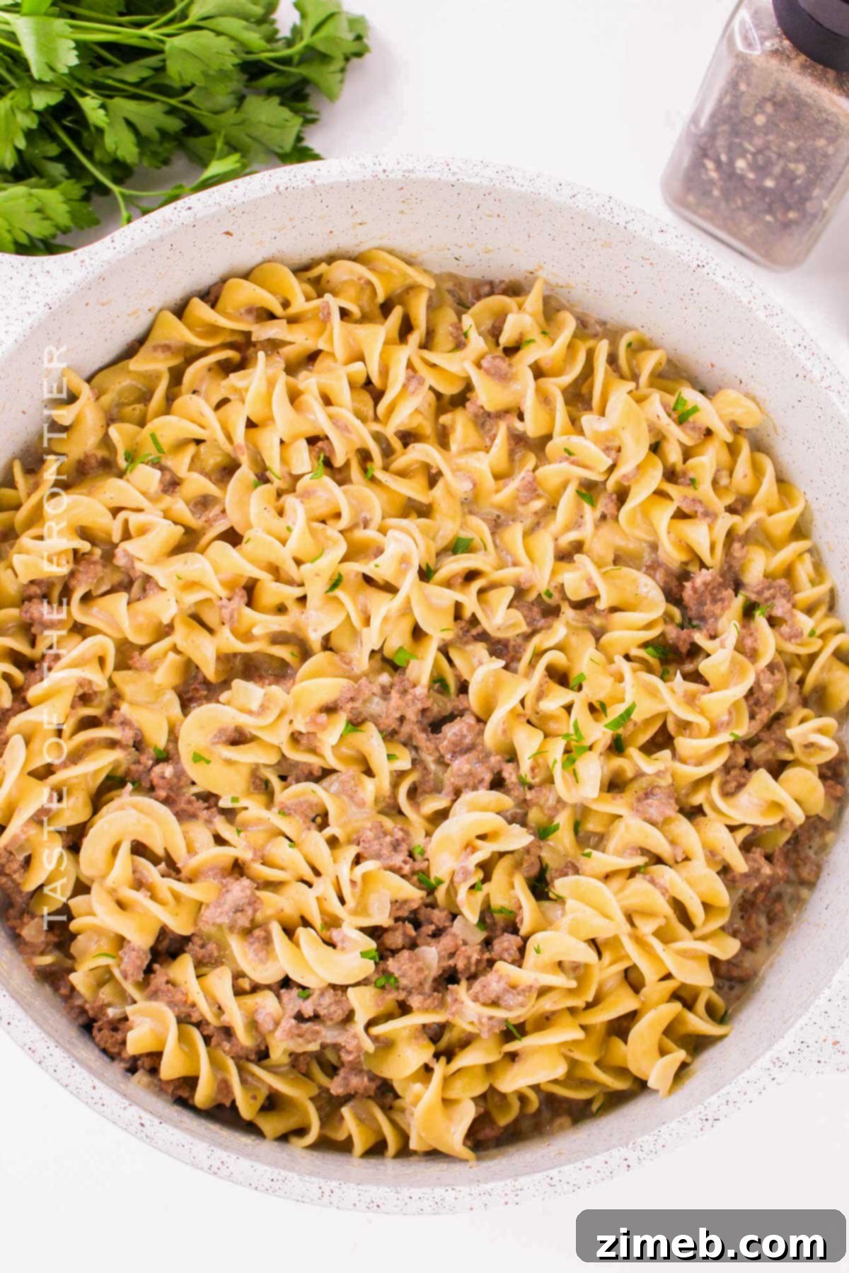 Hearty Beef Noodle Bowl 3 mixing the beef and noodles in a skillet