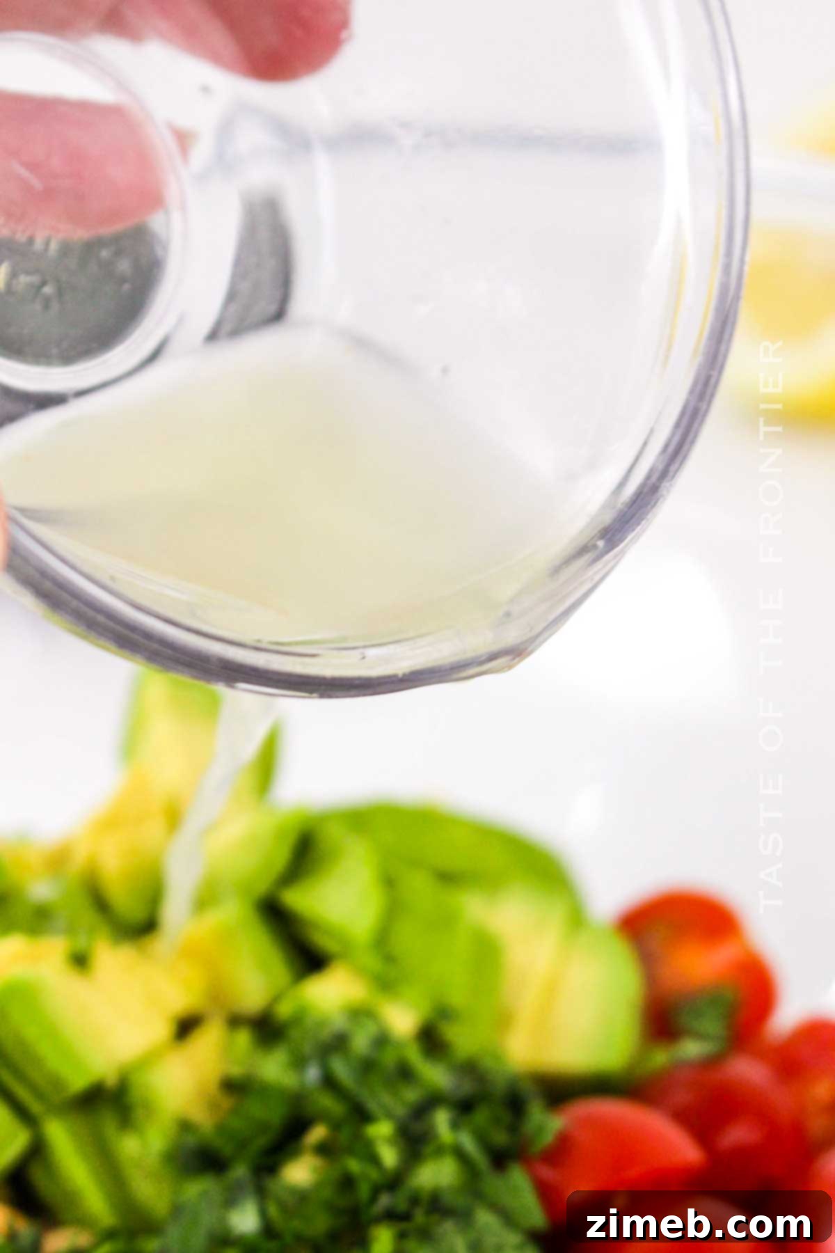 Adding lemon juice to the Chickpea Avocado Salad ingredients.
