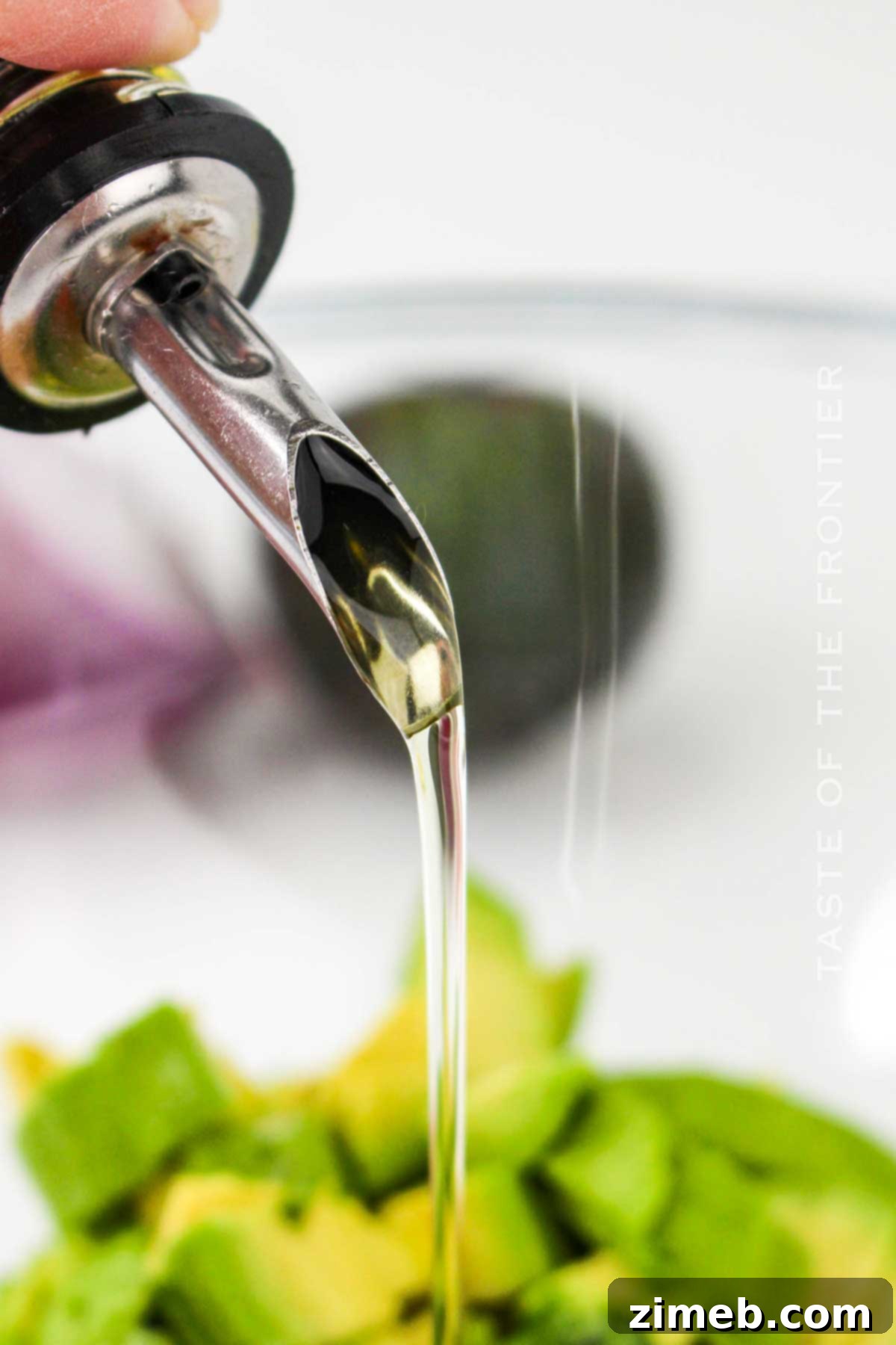 Adding olive oil to the salad ingredients for dressing.