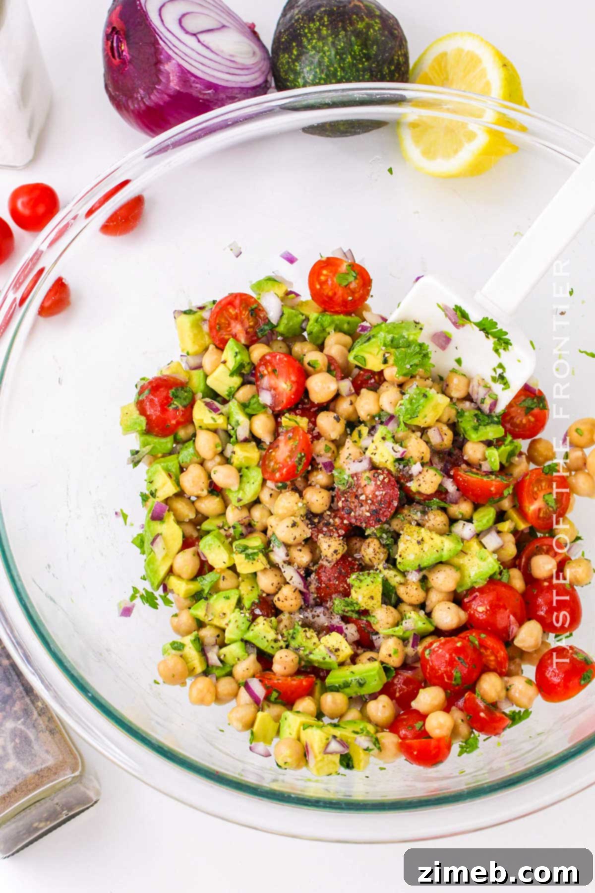 Tossing the ingredients of Chickpea Avocado Salad in a bowl.