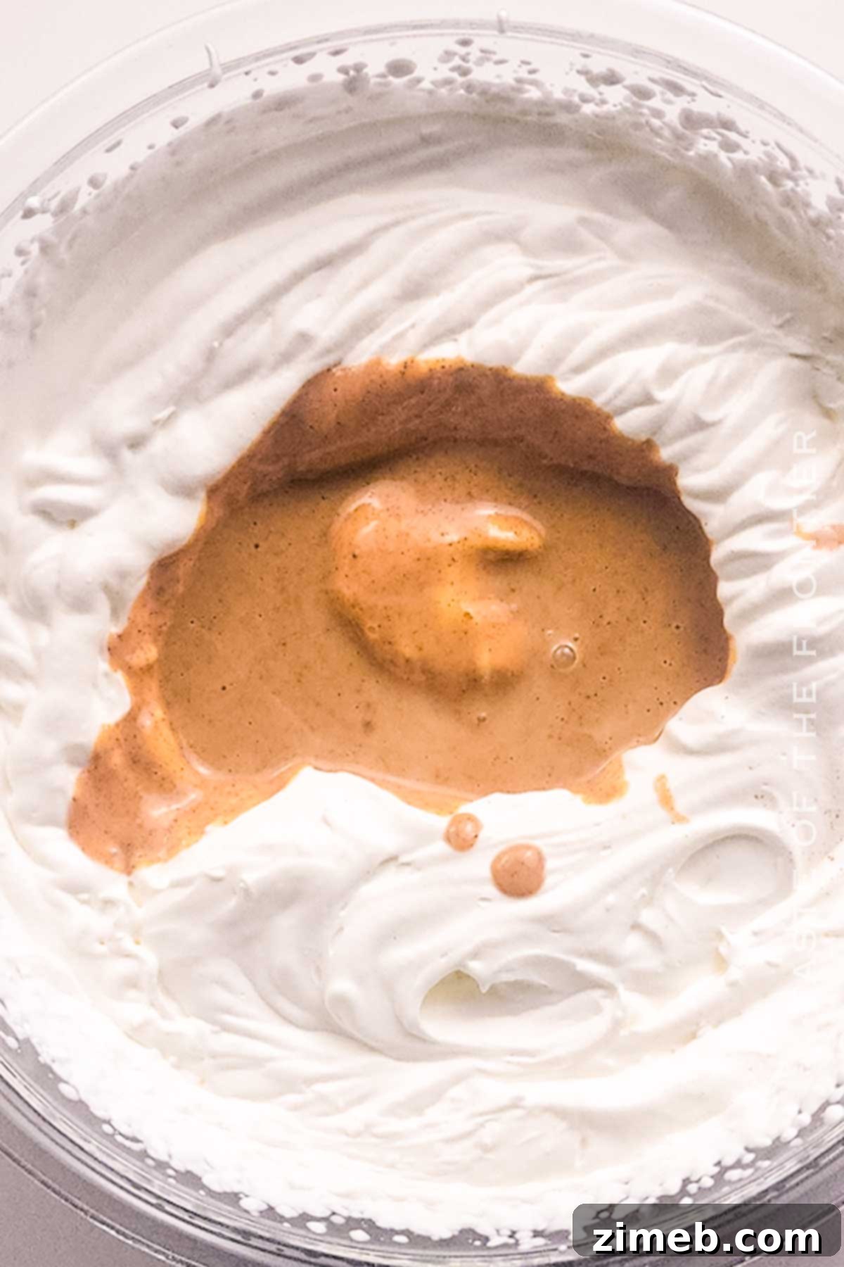 Folding whipped cream into pumpkin and condensed milk mixture