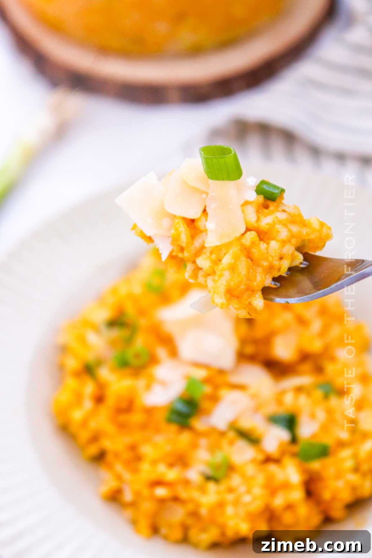 Velvet Pumpkin Risotto 15 A close-up of a serving of Pumpkin Risotto with grated Parmesan and fresh herbs, ready to be enjoyed.