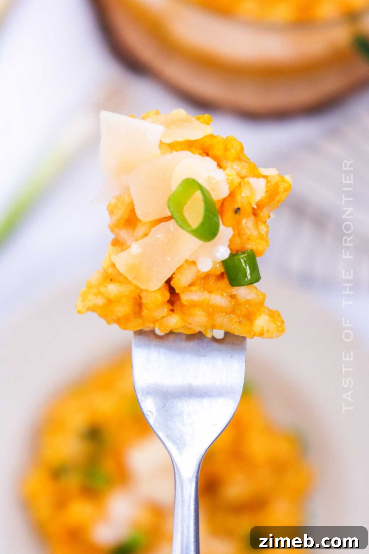 Velvet Pumpkin Risotto 8 A close-up of a spoon lifting a bite of creamy parmesan cooked rice, showing the texture and warmth.
