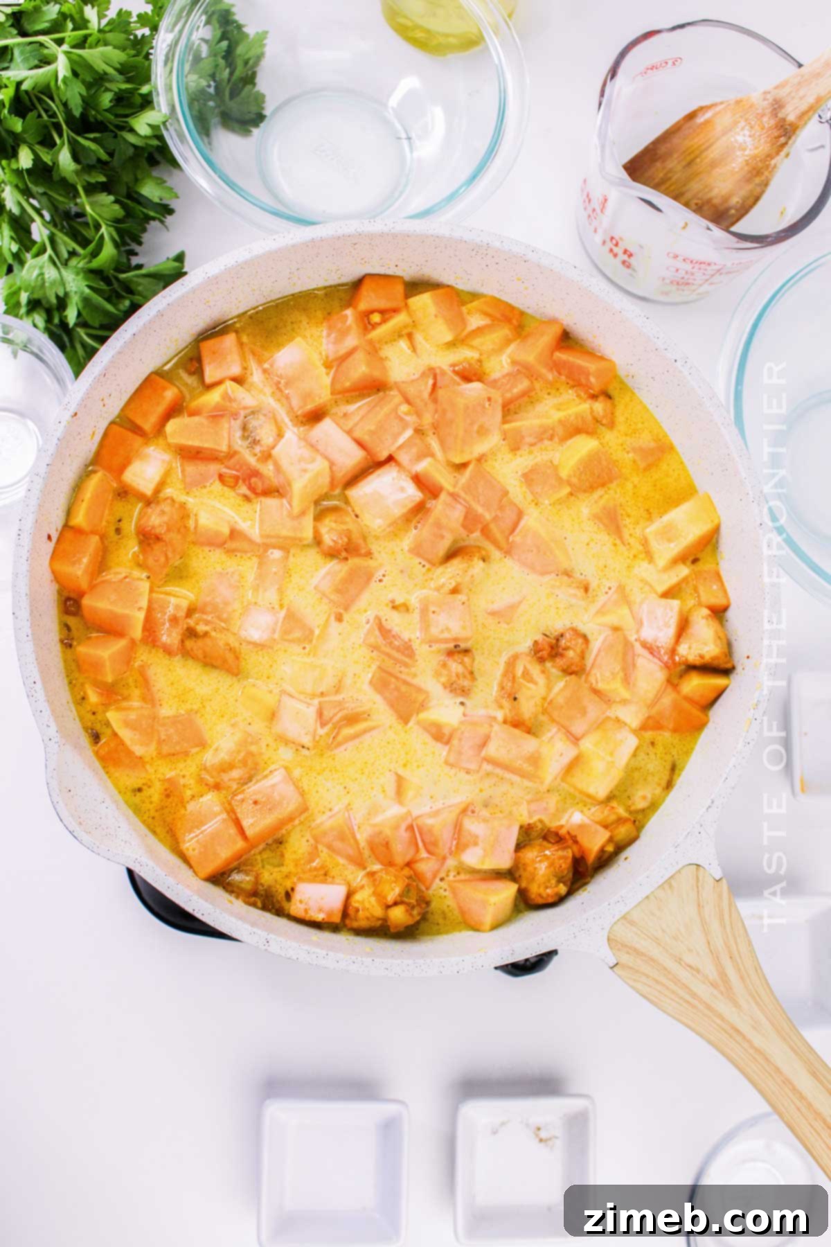 Cooking curry with pumpkin in a large skillet