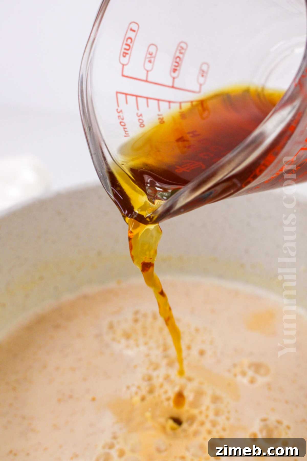 Autumn Pumpkin Chai Latte 6 Final step of making Pumpkin Spice Chai Latte, pouring the finished drink into mugs with garnishes.