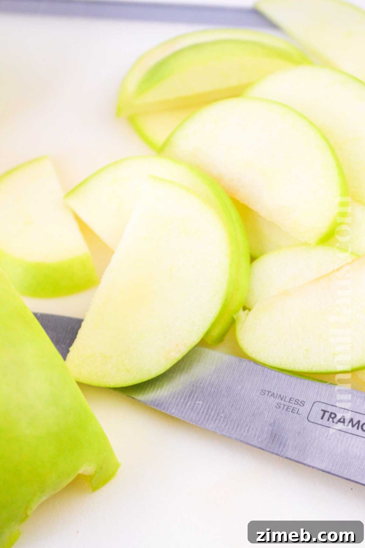 Expertly slicing fresh apples on a cutting board, preparing them for an Easy Puff Pastry Apple Tart.