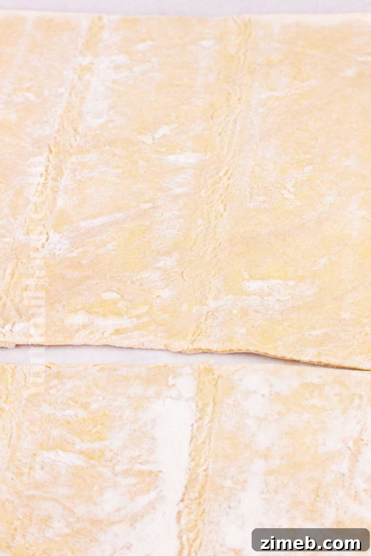 Freshly rolled puff pastry dough, ready for topping with sweet apples to create a delicious tart.