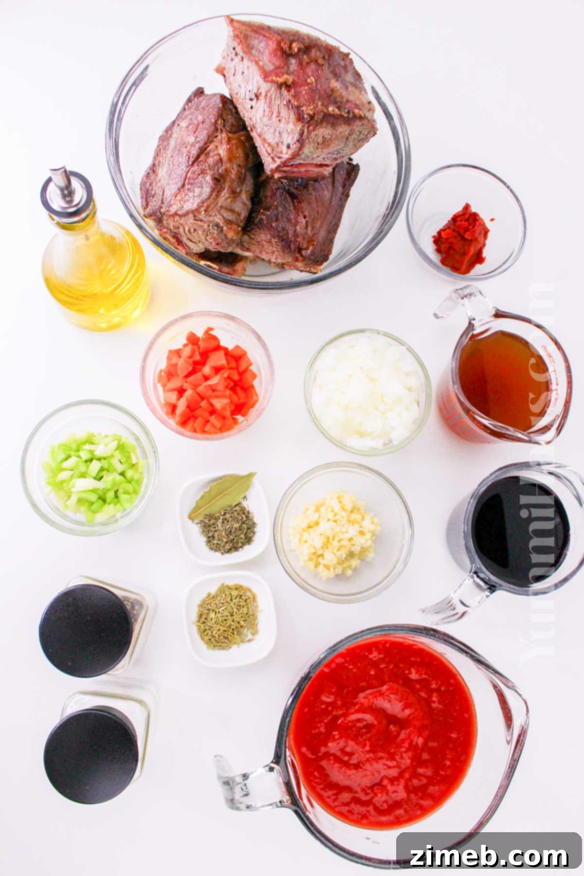 Slow-Braised Beef Short Rib Ragu 4 Raw ingredients for Beef Short Rib Ragu laid out on a table