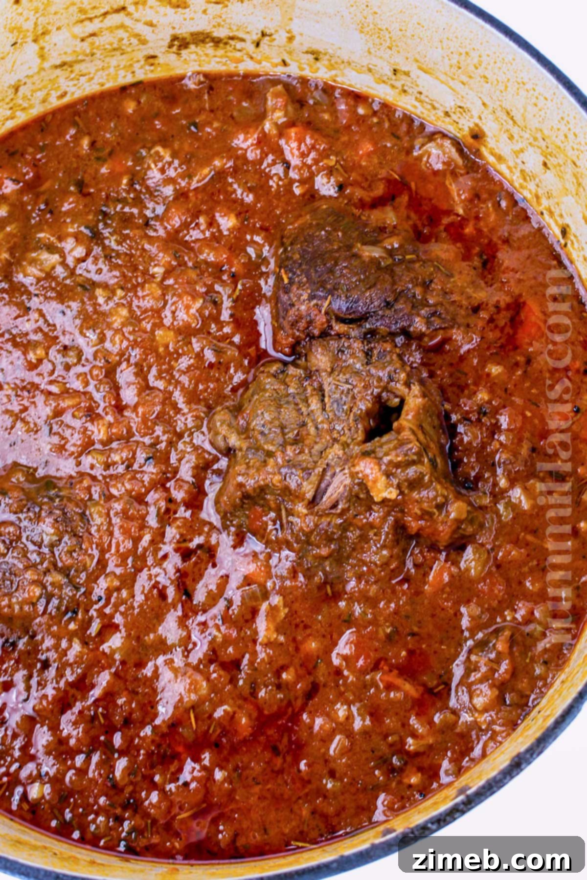 Slow-Braised Beef Short Rib Ragu 7 Beef short rib ragu simmering gently in a Dutch oven on the stovetop