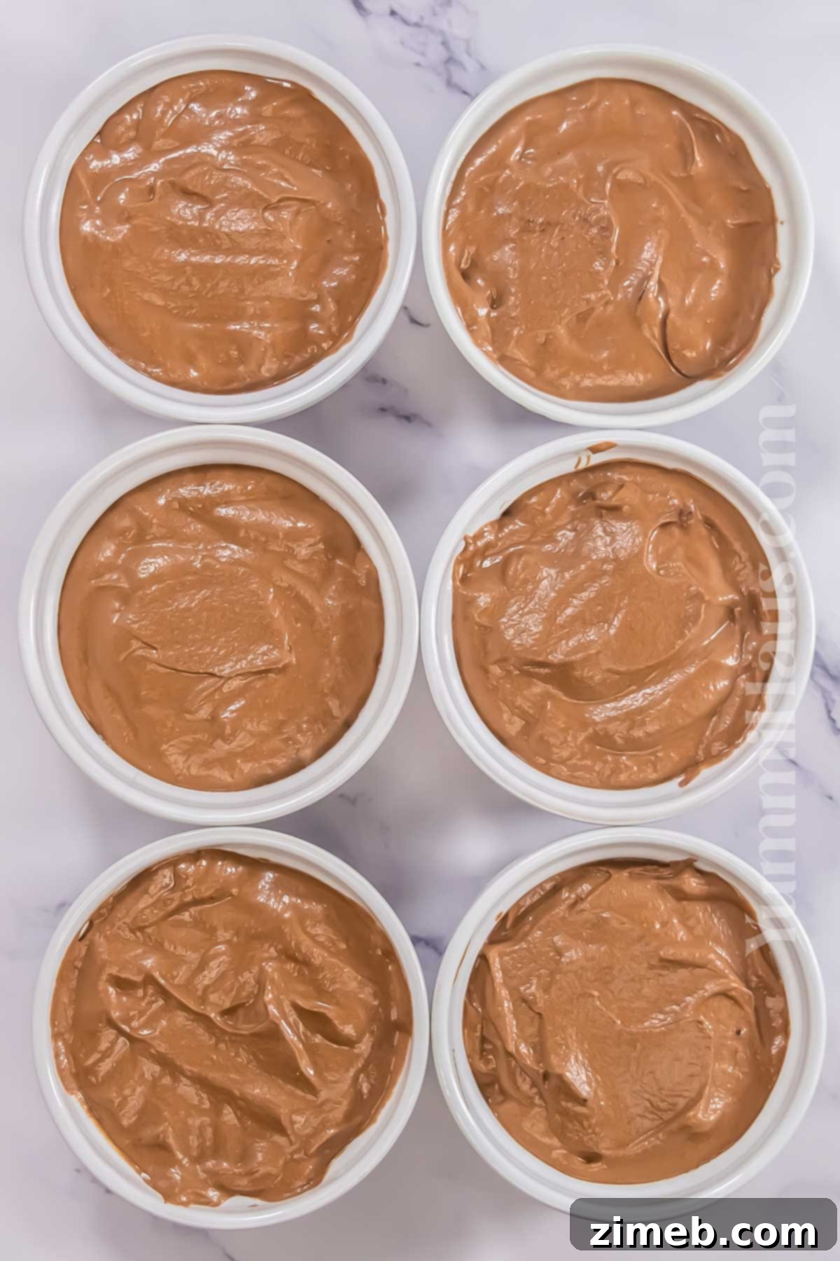Portioning the chocolate mousse into ramekins.