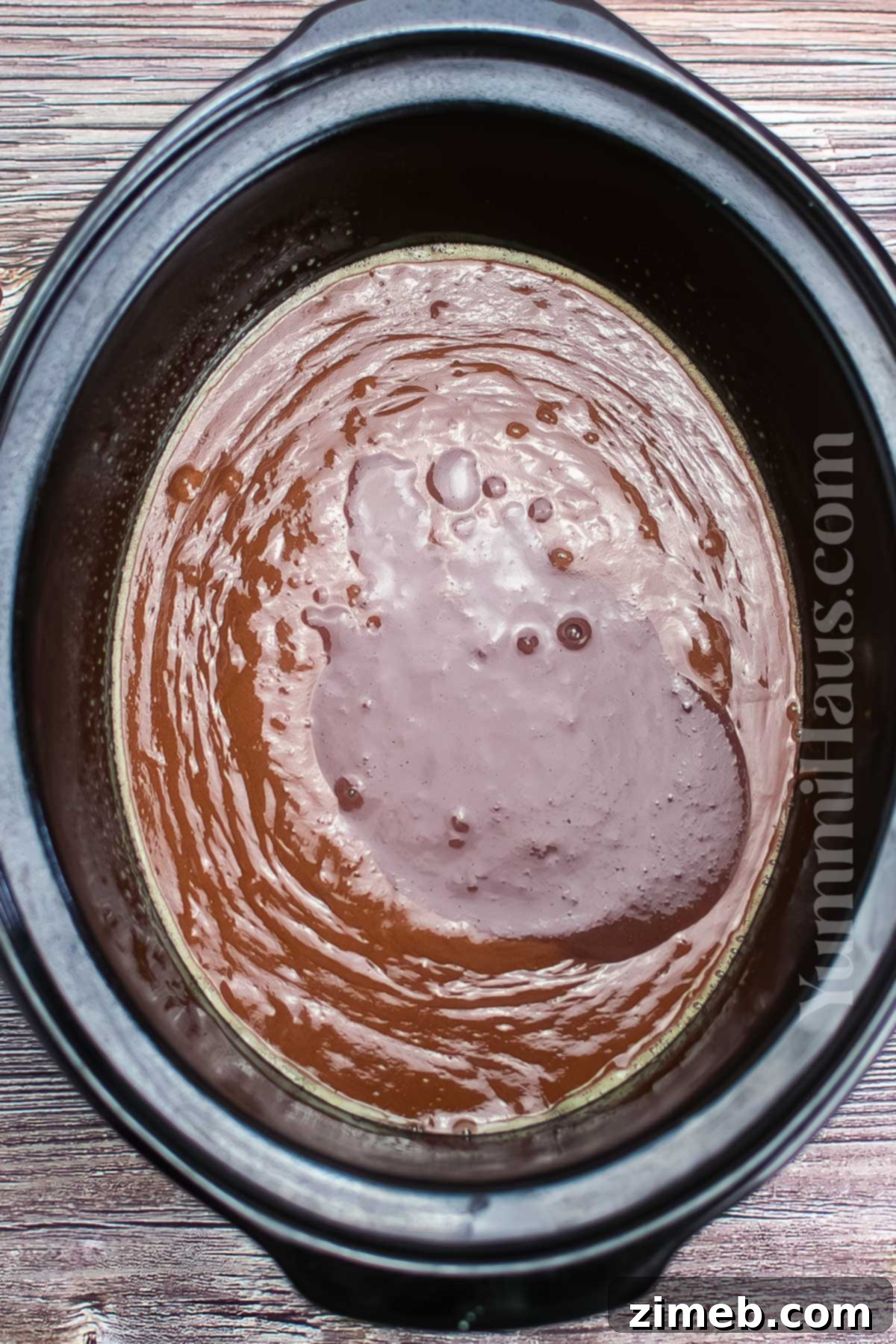 Adding the pudding mix to the cake batter in the slow cooker
