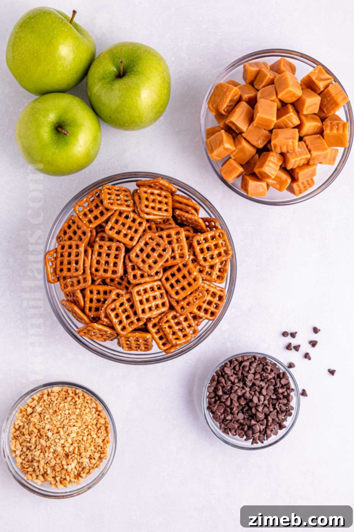Sweet and Salty Caramel Apple Pretzel Bites 4 A vibrant display of ingredients for Caramel Apple Pretzel Bites, including pretzels, caramels, apples, and chocolate.