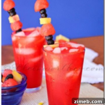 A glass of Watermelon Cherry Limeade with fresh watermelon and cherry garnishes.