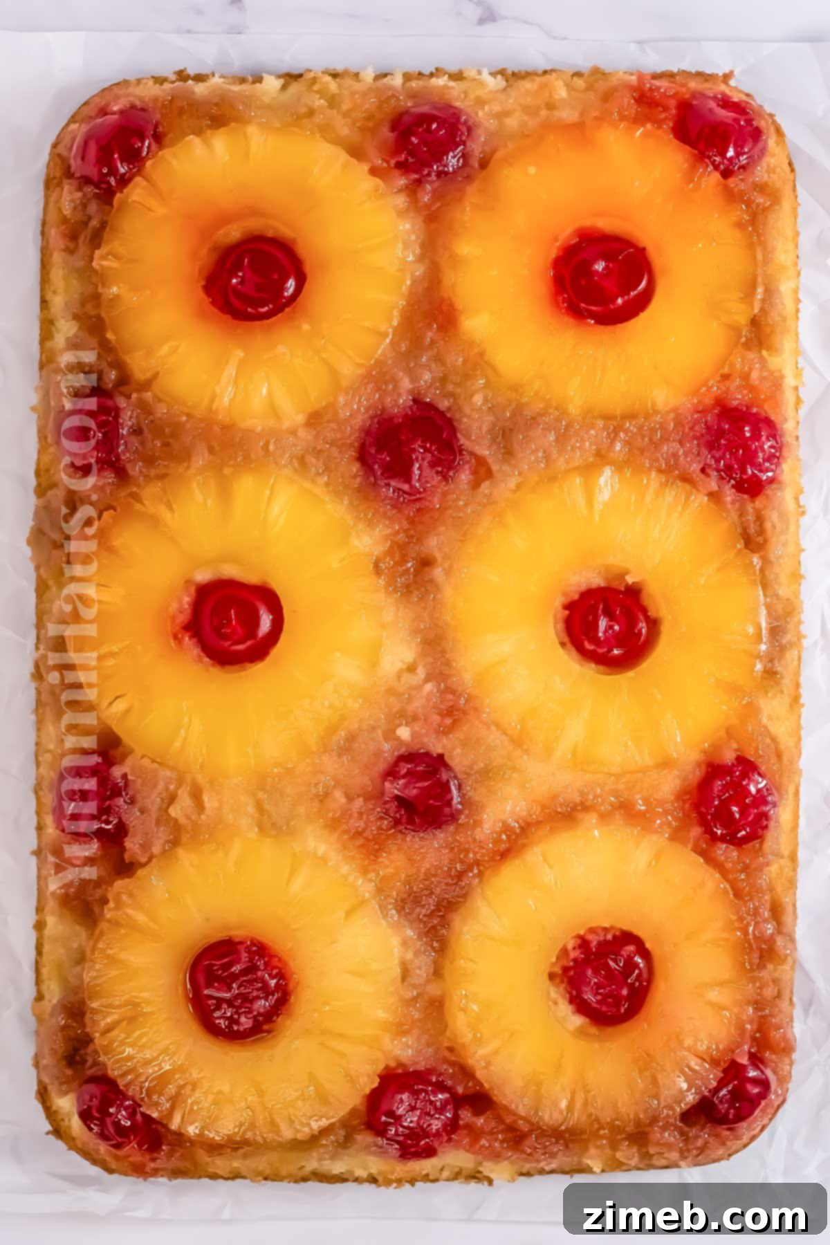 Slice of baked Pineapple Upside Down Cake with fruit