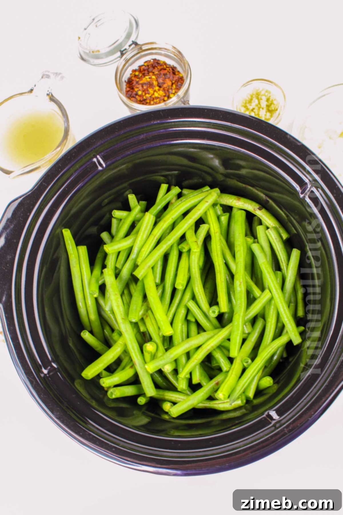 Delicious Crockpot Green Beans 5 Making slow cooker veggies with green beans and bacon.