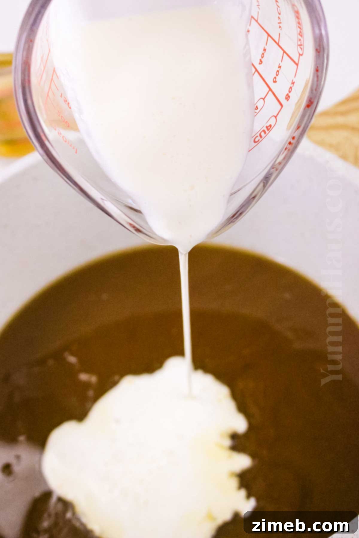 Decadent Rum Sauce 6 Adding heavy cream to the rum sauce mixture.
