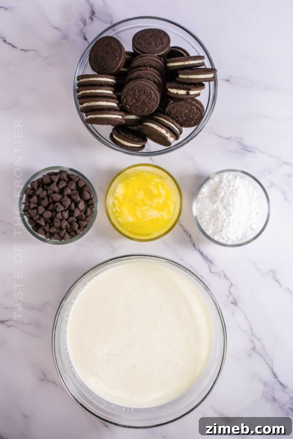 Decadent Oreo Mousse Cake 4 Ingredients for Oreo Mousse Cake laid out: Oreos, butter, chocolate chips, heavy cream, confectioner's sugar.