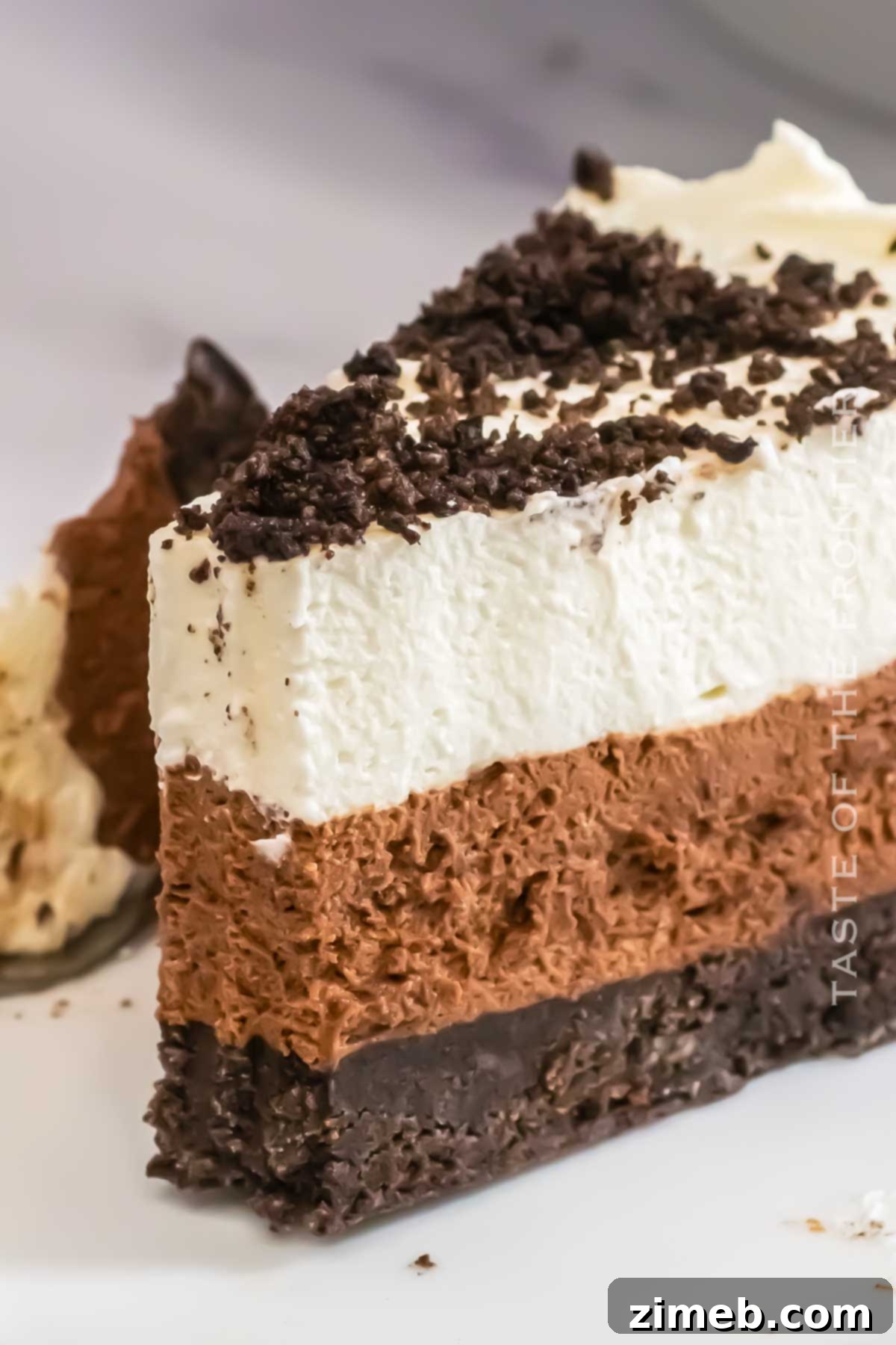 Decadent Oreo Mousse Cake 8 Finished Oreo Mousse Cake with a slice removed, revealing the layers.
