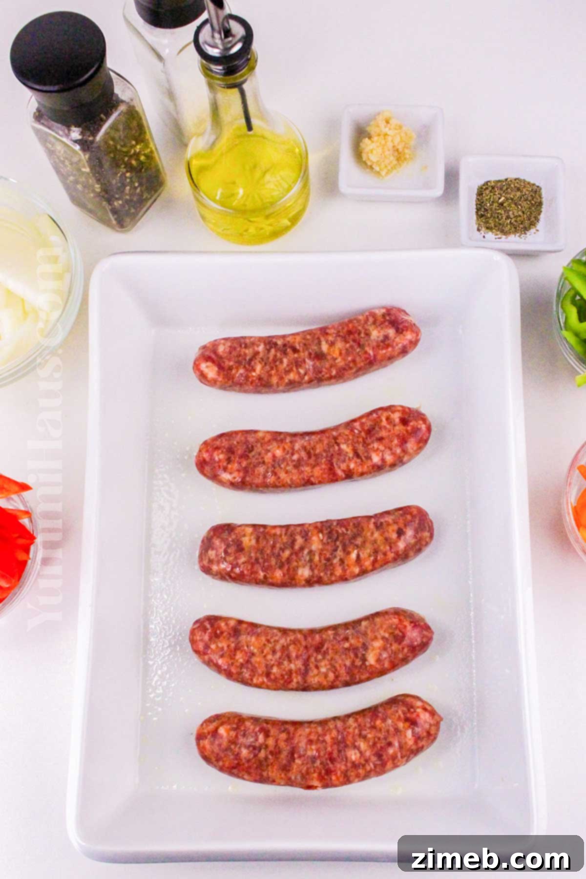 Preparing the Italian sausage and vegetables for oven baking.