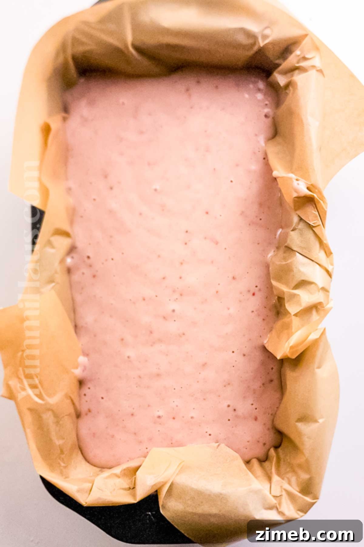 A step-by-step image of glazing a baked Strawberry Loaf Cake with pink icing and fresh berries.