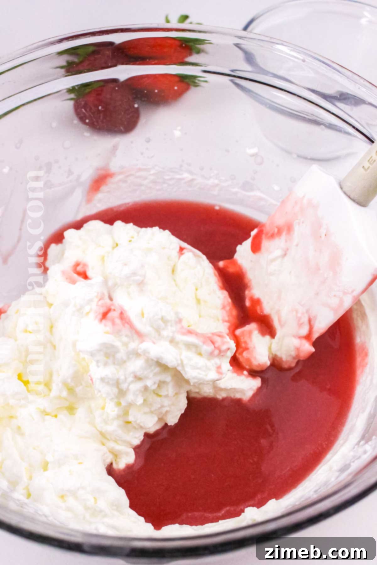 Folding in the whipped cream into strawberry puree.