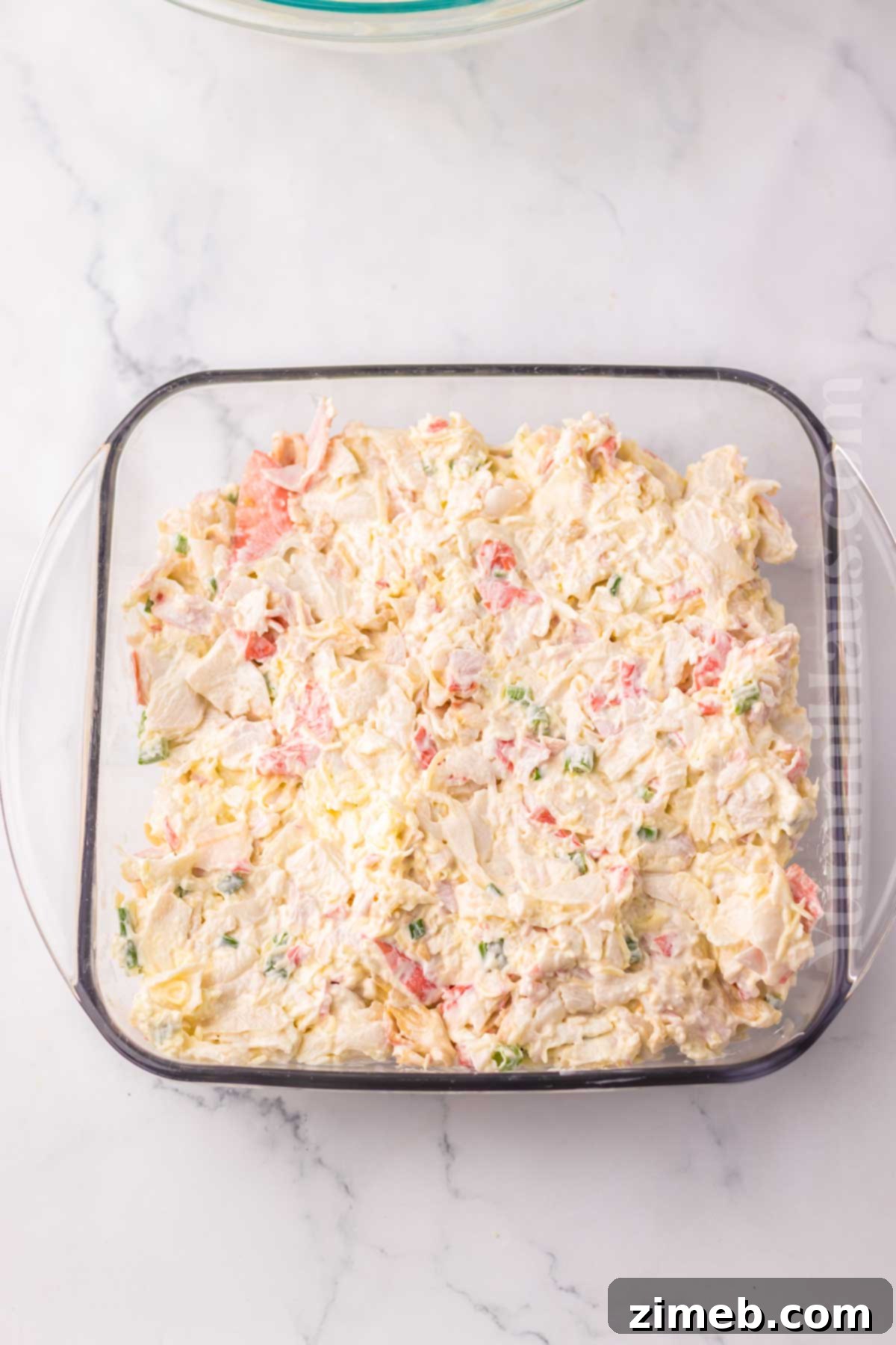 Creamy Wonton Crab Dip 6 Crab Rangoon Dip mixture in a baking dish, ready to be baked.