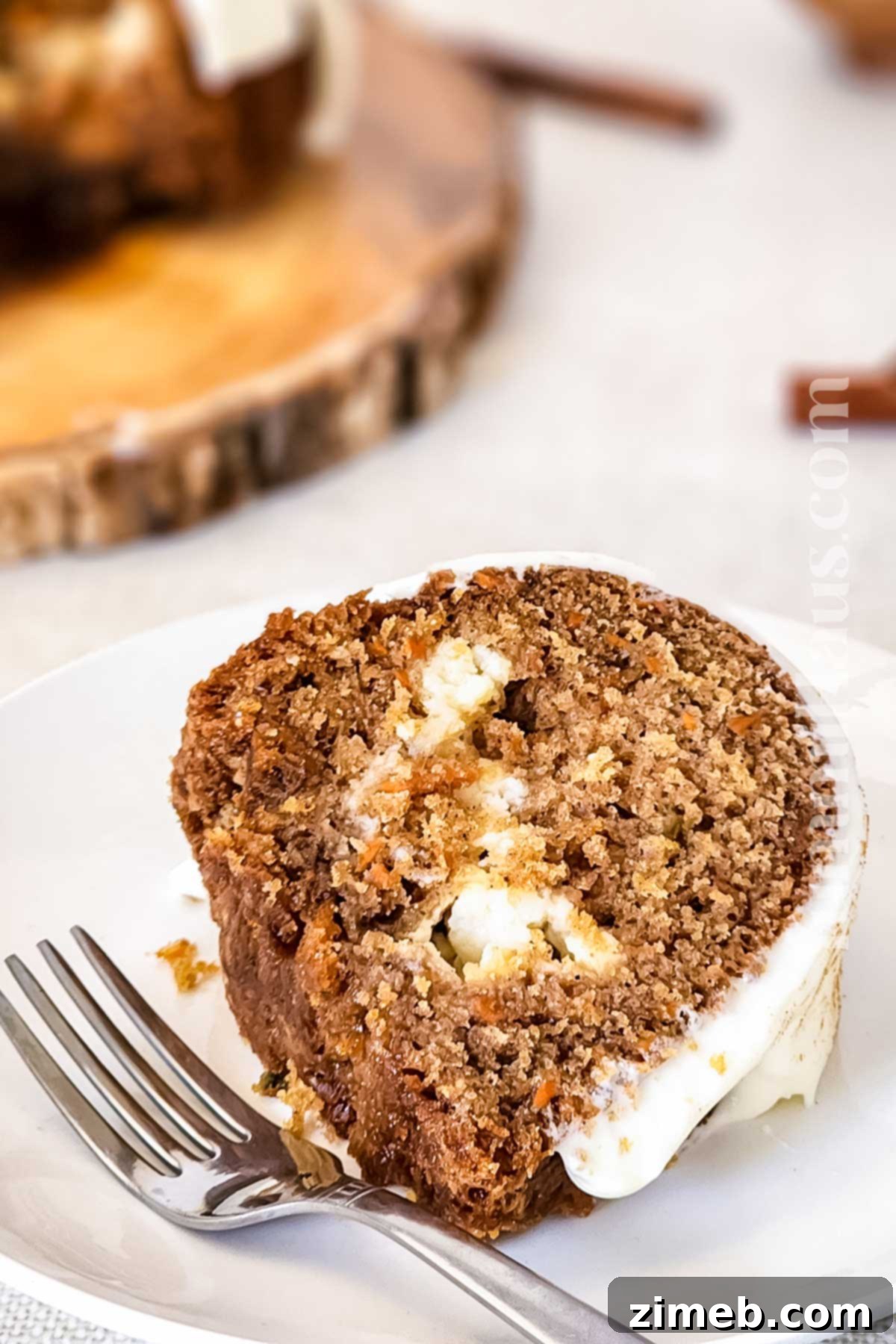 Carrot Bundt Cake with cream cheese filling and glaze on a white platter.