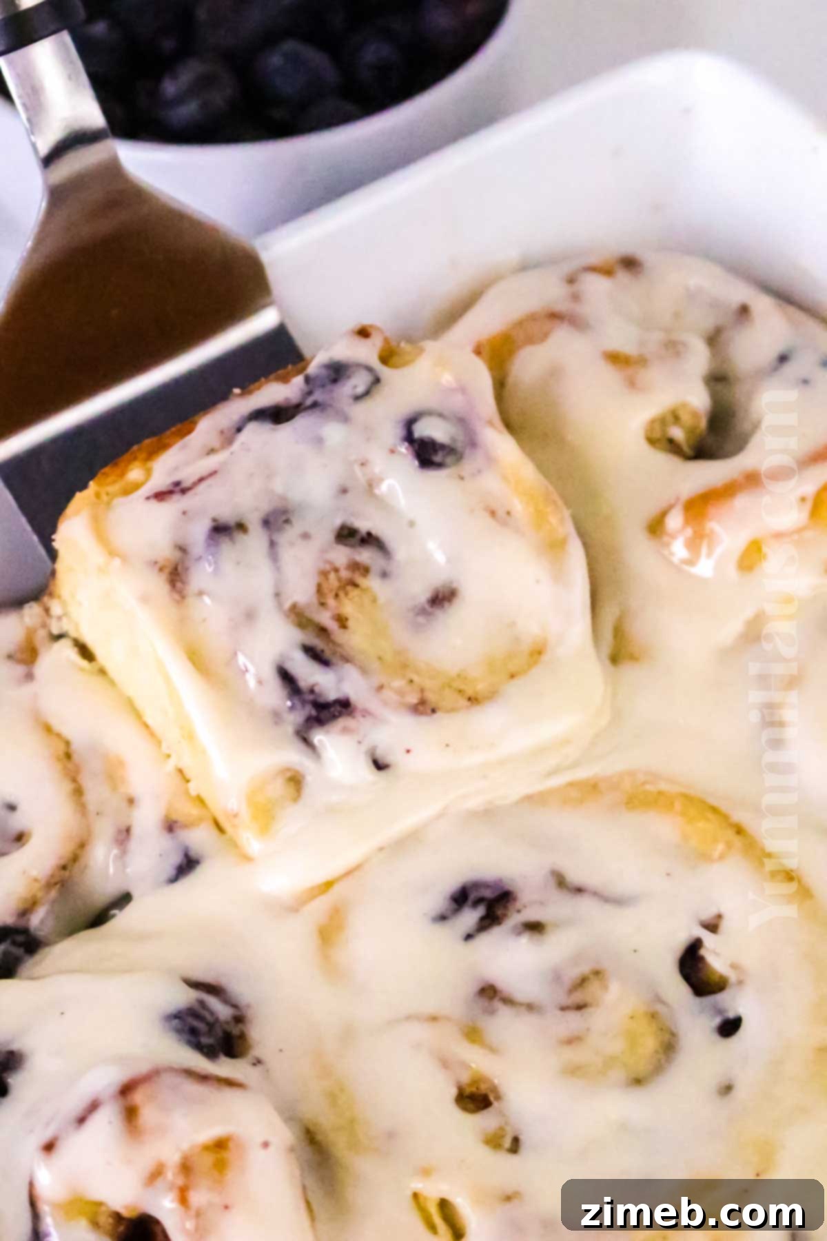 Luscious Blueberry Cinnamon Swirls 14 Freshly baked cinnamon rolls with sweet glaze and scattered fresh blueberries.