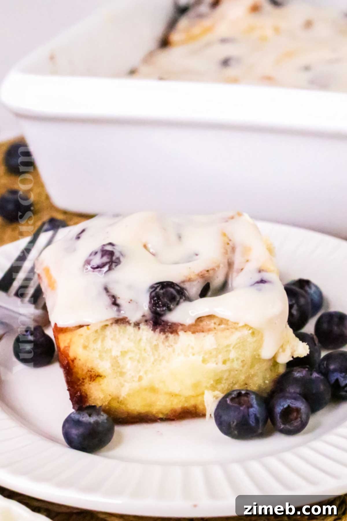 Luscious Blueberry Cinnamon Swirls 3 Close-up of golden brown blueberry cinnamon rolls with sweet glaze, showcasing fluffy texture and juicy berries.