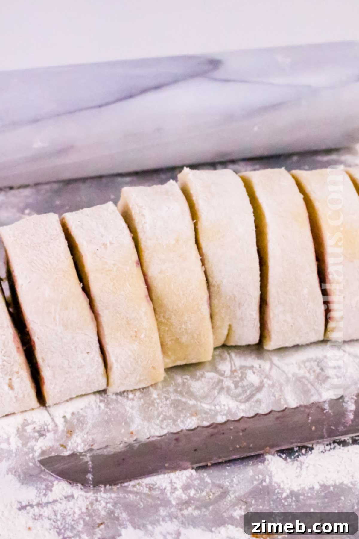 Luscious Blueberry Cinnamon Swirls 7 Rolling and preparing cinnamon roll dough with blueberry filling on a floured surface.
