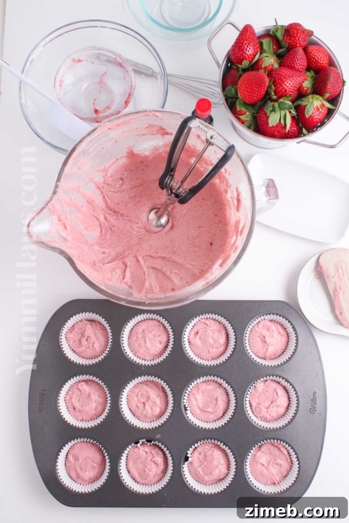 Sweet Strawberry Delights 7 Hands pouring strawberry puree into a stand mixer with cupcake batter