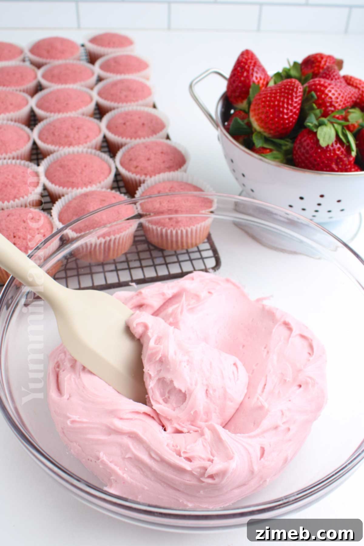 Sweet Strawberry Delights 8 Close-up of strawberry cream cheese frosting being piped onto a cupcake